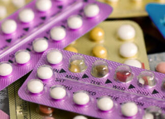 Kontracepcija, da ali ne? Oral contraceptive pill on pharmacy counter with colorful pills strips background.