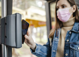 Urbana – kartica mestnega prometa Photo of a woman driving in the bus and paying for a ticket with smart phone