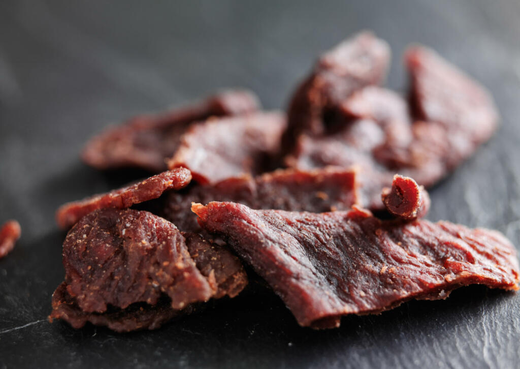 pile of beef jerky shot with selective focus on slate table