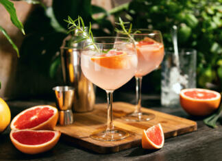 Grenivka in njene skrivnosti Pink grapefruit and rosemary gin cocktail served in prepared gin cocktail glass on a tropical beach bar