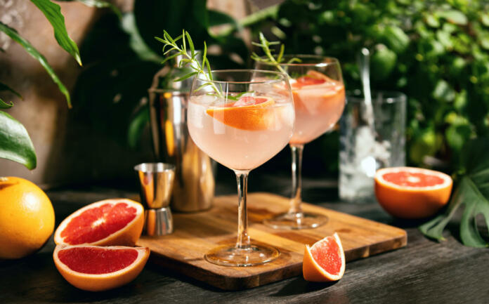 Pink grapefruit and rosemary gin cocktail  served in prepared gin cocktail glass on a tropical beach bar