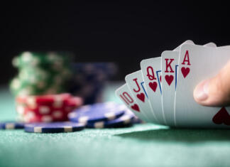 Študentska poker liga Playing poker in a casino holding winning royal flush hand of cards concept for gambling, betting and winning