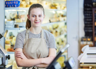 Bodi vztrajen in delaj vsak dan Portrait Ot Teenage Girl Working In Delicatessen Food Shop As Job Experience