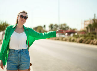 Štoparka Pretty woman hitch-hiking on the roadside.