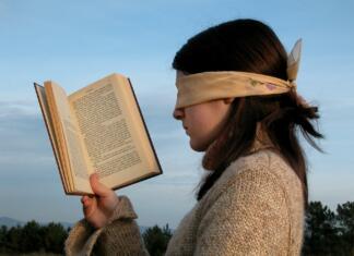 6 tipov prokrastinatorja: Kateri si ti in kako si lahko pomagaš? Ženska s prevezo čez očmi v rokah drži knjigo