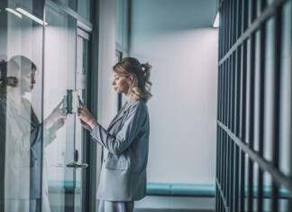 Želite izboljšati svoje zaposlitvene možnosti? Dve besedi: BTC Campus Reading code. Young confident business woman holding smartphone to combination lock on office door in building