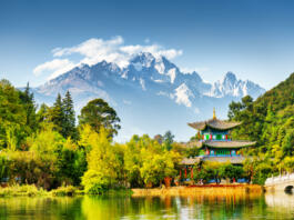 Scenic view of the Jade Dragon Snow Mountain and the Moon Embracing Pavilion on the Black Dragon Pool in the Jade Spring Park, Lijiang, Yunnan province, China.