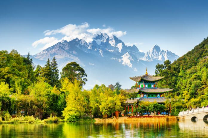 Scenic view of the Jade Dragon Snow Mountain and the Moon Embracing Pavilion on the Black Dragon Pool in the Jade Spring Park, Lijiang, Yunnan province, China.