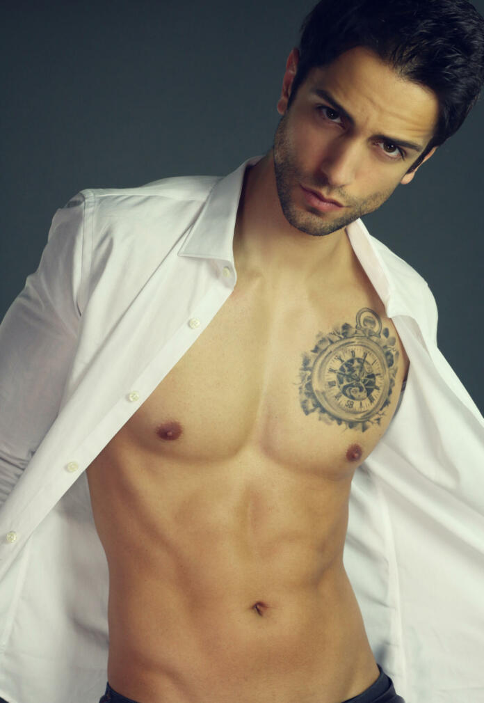 Sensual man with open shirt over a gray background