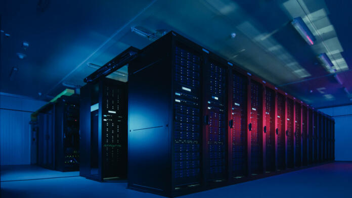 Shot of Data Center With Multiple Rows of Fully Operational Server Racks. Modern Telecommunications, Cloud Computing, Artificial Intelligence, Database, Supercomputer Technology Concept. Shot in Dark with Neon Blue, Pink Lights.