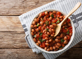 Slovenija in njene zaščitene jedi Stewed cranberry beans or borlotti in tomato sauce with herbs close-up in a bowl on the table. horizontal top view from above