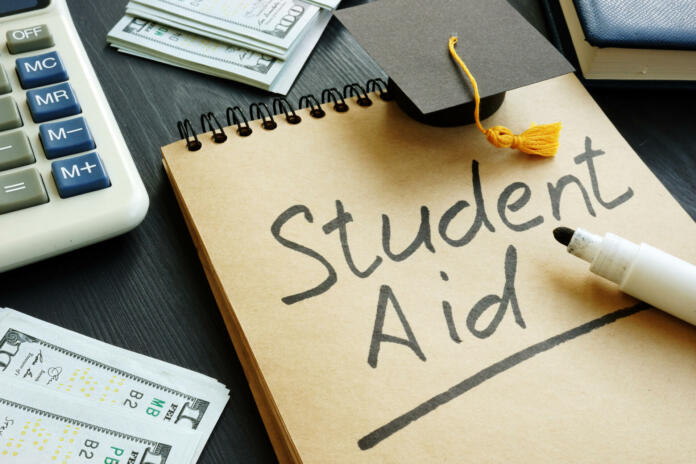 Student aid sign with small graduation cap and money.