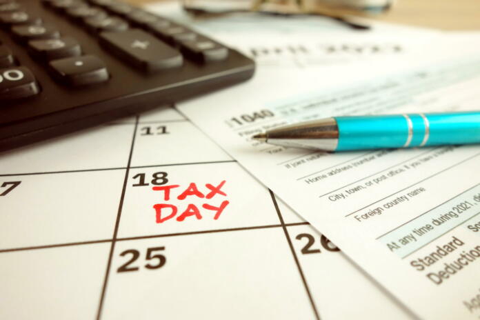 Tax payment day marked on a calendar - April 18, 2022 with 1040 form, financial concept