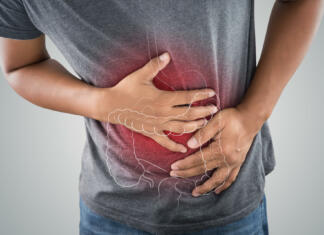 Prebavne motnje – kako se jih rešiti? The photo of large intestine is on the man's body against gray background, People With Stomach ache problem concept, Male anatomy