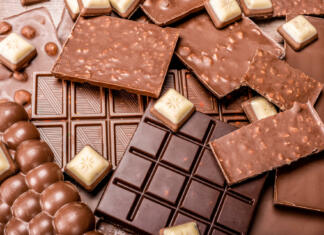 ČokoLJana – največji slovenski čokoladni sejem Top view of arrangement of various types of chocolate. Delicious chocolate mix. Top view of pieces of chocolate bar with chips. bar with scattered pieces