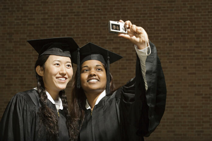 Two female graduates taking a photograph