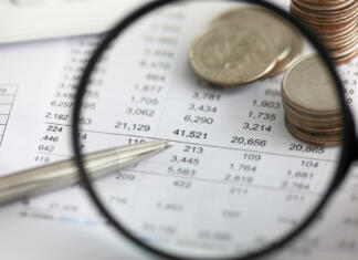 Svetovalnica – dohodnina View at financial details in table thru magnifying glass close-up