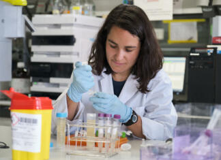 Magisterij ali doktorat Young female researcher working in a real laboratory analysing experimental samples.