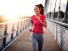 Young woman jogging outdoors on bridge. Concept of healthy lifestyle.