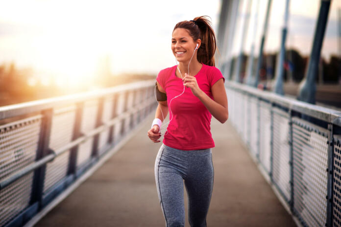 Young woman jogging outdoors on bridge. Concept of healthy lifestyle.