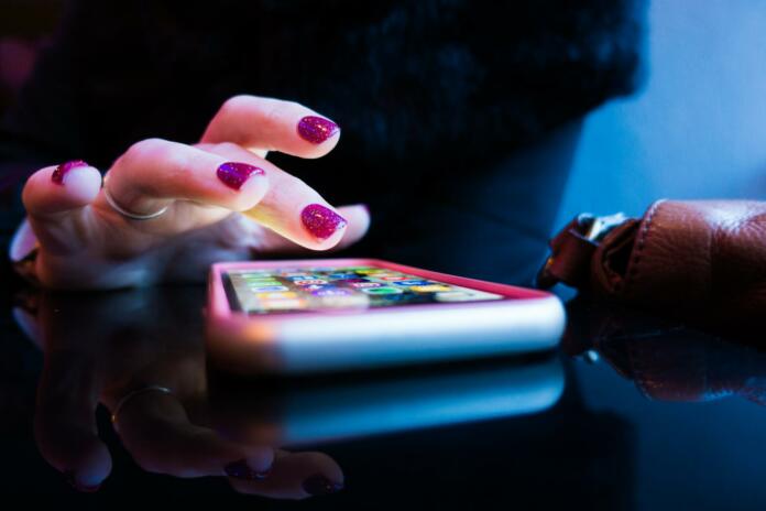 ženski prsti nad pametnim telefonom