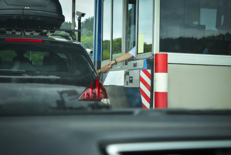 A man pays money to a cashier for a toll road Toll gate motorway entrance