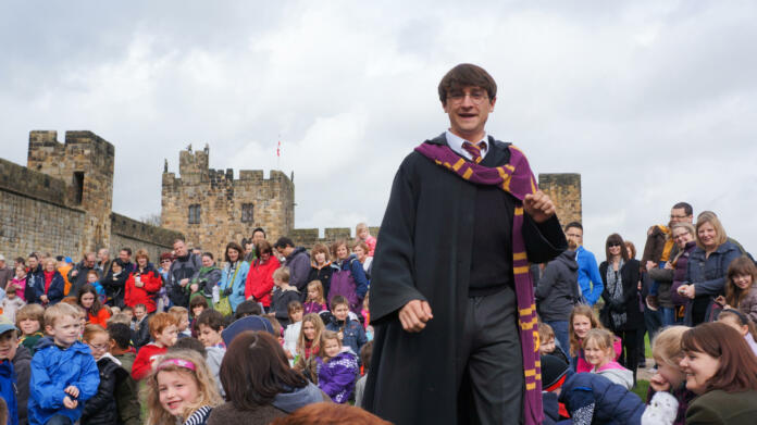 "Alnwick, England - April 02, 2012: A male actor playing the role of film hero Harry Potter to entertain tourists at Alnwick castle in Northumberland England. This castle was used to film parts of the movies"