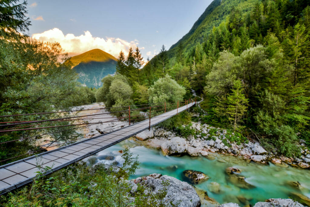 Beautiful evening view of a bridge crossing over Soca River, one of the most beautiful European rivers running through the Soca Valley near Triglav National Park in Slovenia.