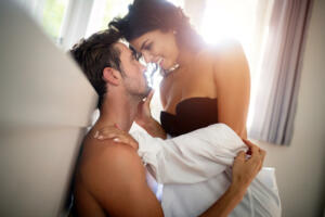 Beautiful young passionate couple in bedroom