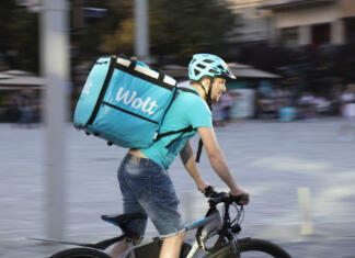 Wolt: nova možnost okusne dostave v Ljubljani Belgrade, Serbia - June 5, 2021: Wolt delivery food service courier riding a bike on city street on a sunny day