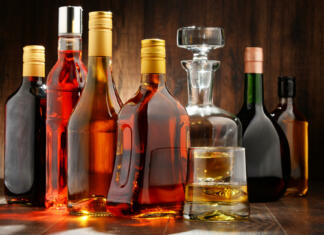 Kaj tvoja izbira pijače pove o tebi Composition with bottles of assorted alcoholic beverages.