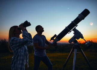 Zemlja začasno dobila novo mini Luno Couple stargazing together with a astronomical telescope.
