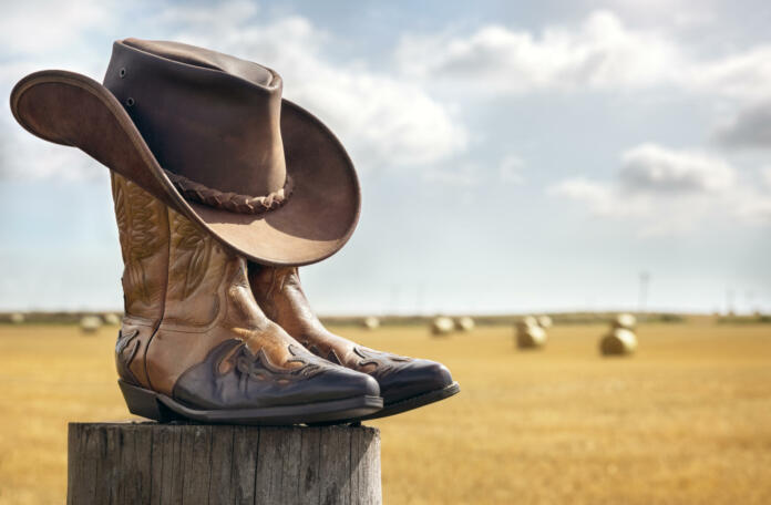 Cowboy boots and hat at ranch, country music festival live concert or line dancing concept