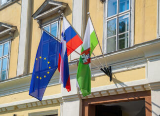 Dan samostojnosti in enotnosti European, Slovenian national and Ljubljana city flags on the wall of town hall in the center of Ljubljana - capital of Slovenia