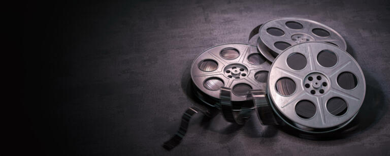 Film reels on black background. Movie, video and cinema prodaction and edition concept. 3d illustration