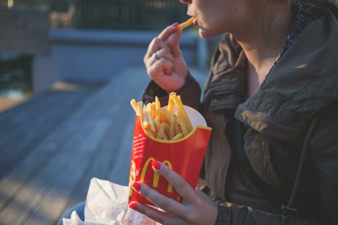 Moški v rokah drži McDonald's krompirček