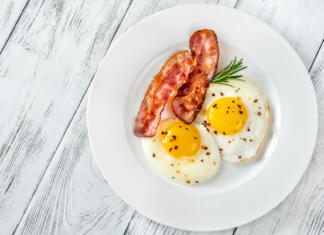 Jutranji tek Fried eggs with bacon rashers on the white plate