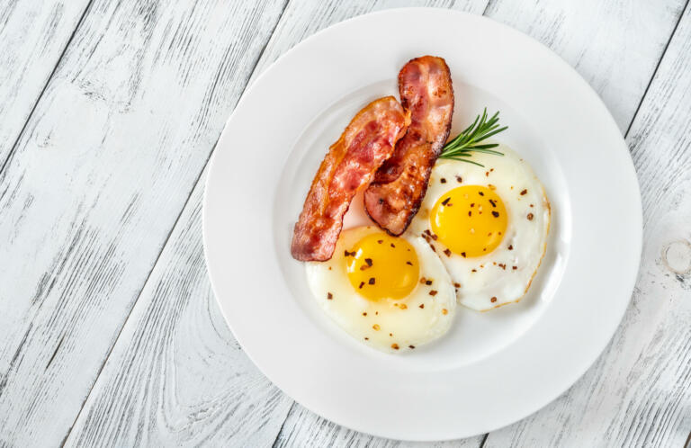Fried eggs with bacon rashers  on the white plate