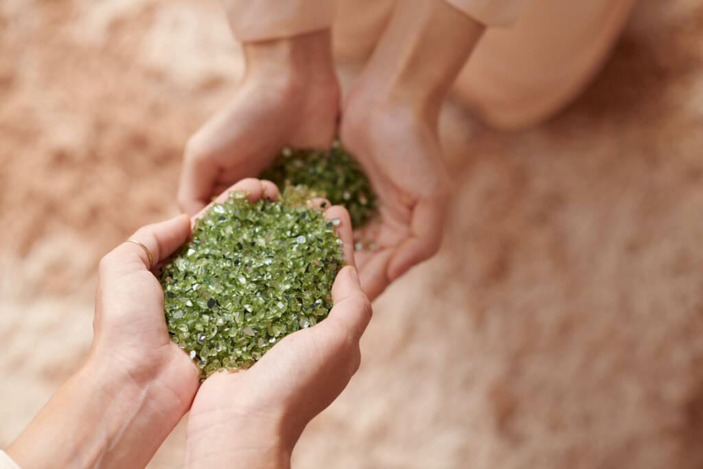 Hands of woman holding handful of nurdle, pre-production microplastic pellets