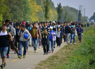 Povečanje nezakonitih prehodov na meji ni nevarno za Slovenijo Hegyeshalom, Hungary - October 6, 2015: Group of refugees leaving Hungary. They came to Hegyeshalom by train and then they leaving Hungary and go to Austria and then to Germany. Many of them escapes from home because of civil war.