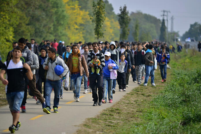 Hegyeshalom, Hungary - October 6, 2015:  Group of refugees leaving Hungary. They came to Hegyeshalom by train and then they leaving Hungary and go to Austria and then to Germany. Many of them escapes from home because of civil war.