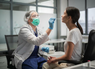 Ali prihaja drugi val koronavirusa? In the laboratory, tests for coronavirus by polymerase chain reaction are carried out, a smear is taken from the nasopharynx of a female patient.