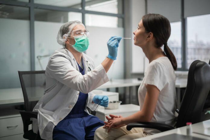 In the laboratory, tests for coronavirus by polymerase chain reaction are carried out, a smear is taken from the nasopharynx of a female patient.