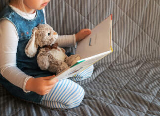 Študent priporoča: najlepše slikanice založbe Morfem Punčka bere knjigo na kavču, v naročju ima plišastega zajčka