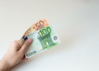 Komentar: 150 evrov ali Bili smo študentje Man holding a hundred and fifty Euro banknote in his handsMan holding a hundred and fifty Euro banknote in his hands