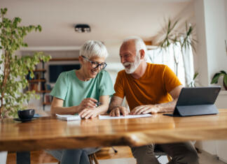 Že razmišljaš o upokojitvi? Zakaj ne? Mature husband, helping his wife with their business, at home office.