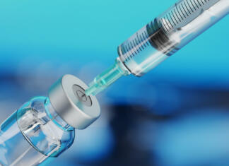 Antivaxerji (anti-vaccination) so nova oblika biološkega terorizma Medical disposable syringe for vaccine injection and glass vial on blue blur background.