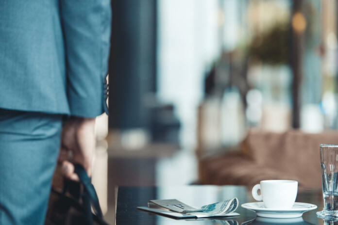 Middle-aged man businessman leaving a business center restaurant holding a briefcse bill payed by cash