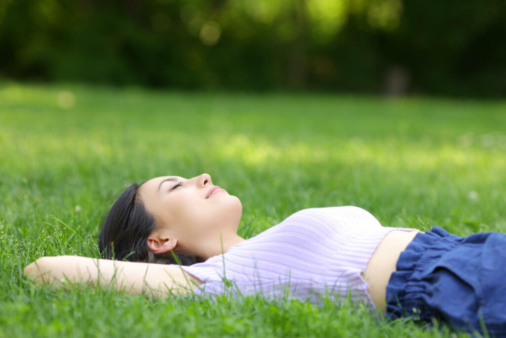 Mixed race woman relaxing lying on the grass