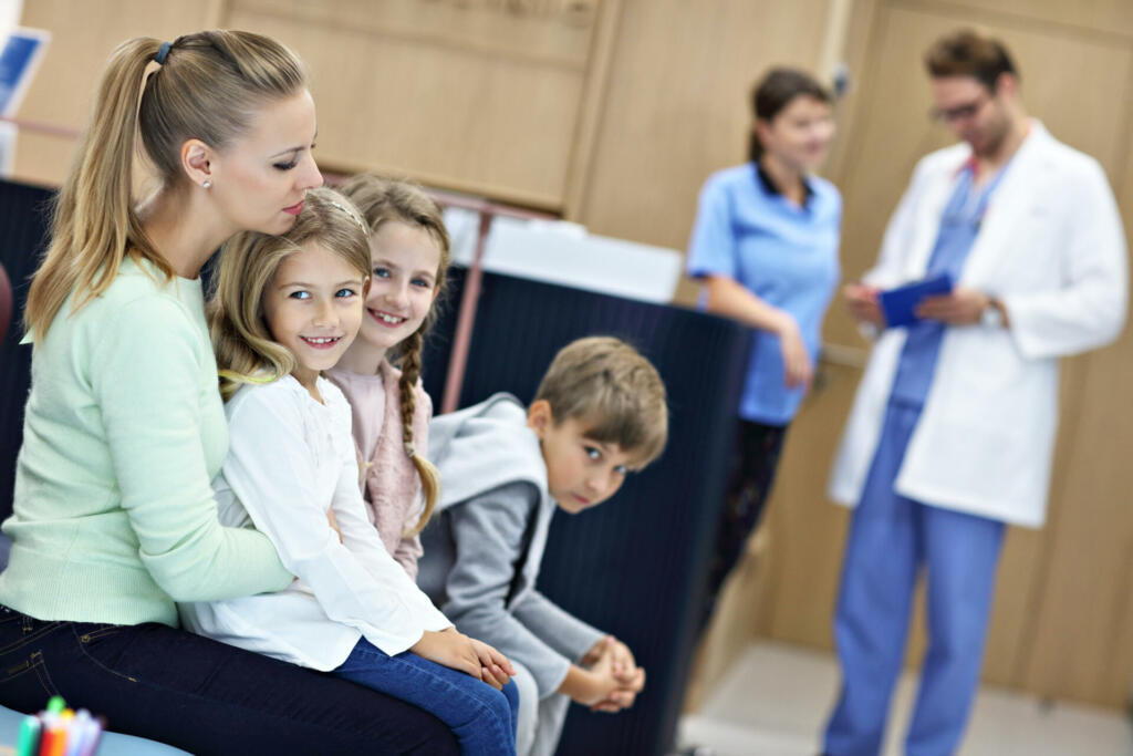 Picture of mother and children waiting in front of registration desk in hospital